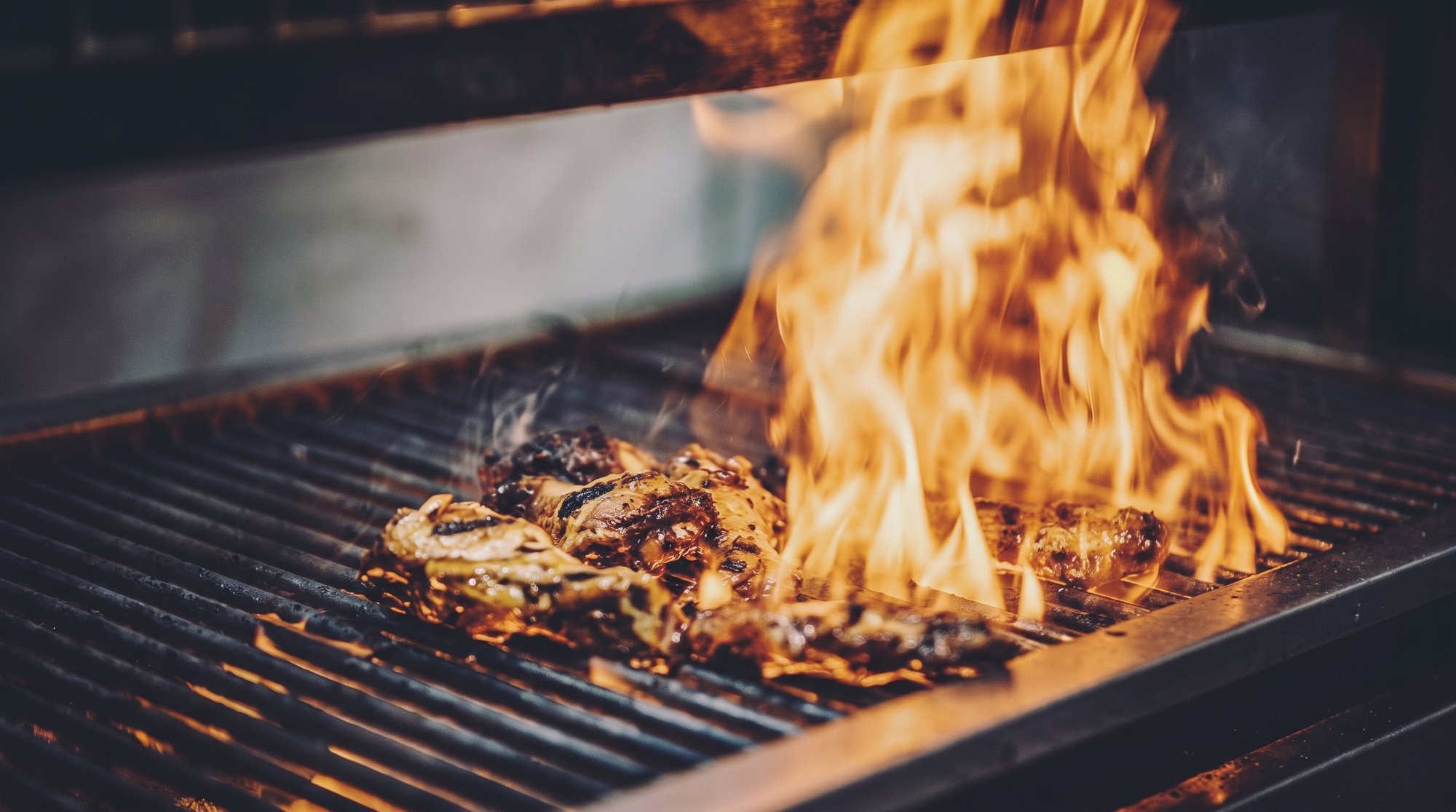 Jerk chicken cooking over open flames at Jerkeez 876